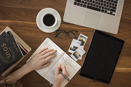 woman holding black pen in front of table thumbnail