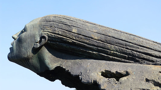 gray statue under blue skies during daytime thumbnail