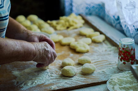 person molding dough on wooden table thumbnail