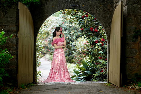 woman standing on gate near green leafed plant thumbnail