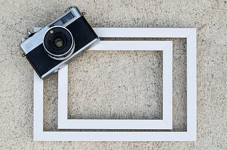 gray and black SLR camera on white wooden surface thumbnail