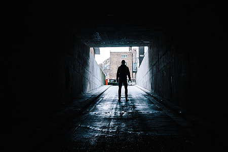 silhouette of a person standing in a parking entrance during day time thumbnail