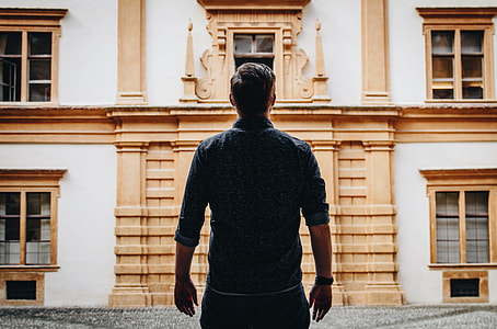 man standing in front of brown building thumbnail