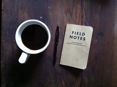 close-up photography of coffee inside white mug beside black click pen and field notes book thumbnail