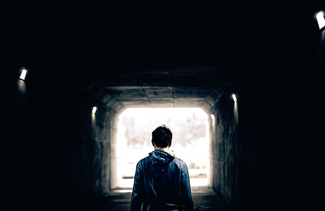 man carrying blue backpack thumbnail