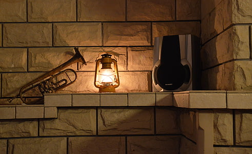 brown kerosene lantern turned on on wall thumbnail