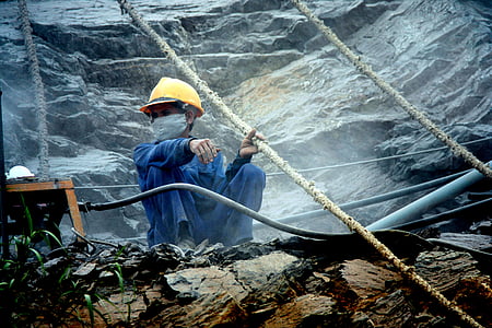 man wearing yellow hard hat sitting on stone thumbnail