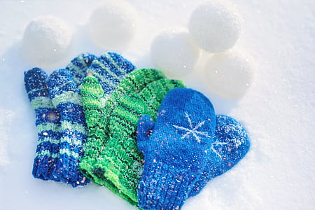 three pairs of blue and green snow gloves on snow thumbnail