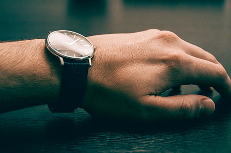 person wearing round silver-colored analog watch thumbnail