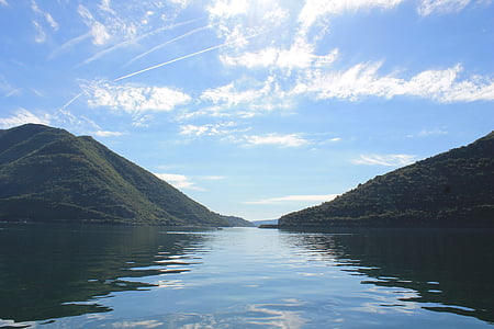 body of water near green covered mountain thumbnail