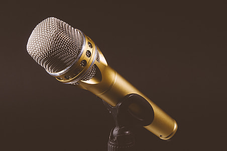 gold wireless microphone on black microphone stand thumbnail