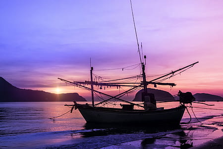 silhouette photo of a boat on body of water thumbnail