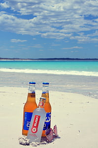three glass bottles on seashore during daytime thumbnail