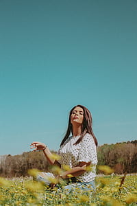 woman in white and black shirt sitting on green grass thumbnail