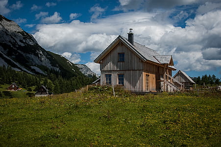 gray and brown wooden house near mountain thumbnail