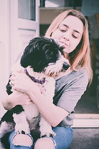 Photo of Woman Holding Black And White Dog thumbnail