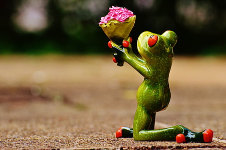 green frog giving flowers while kneeling down figurine thumbnail