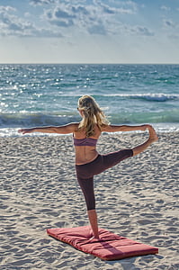 woman doing yoga gesture facing sea thumbnail