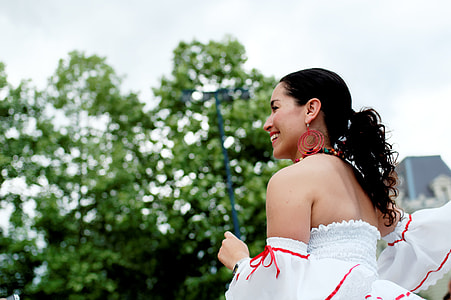 woman standing while smiling at daytime thumbnail