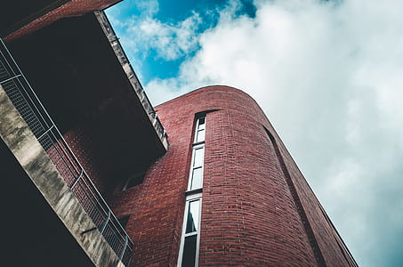 brown concrete building under white cloudy sky thumbnail