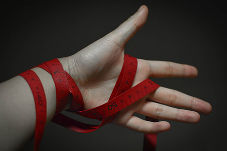 person holding red tape measure thumbnail