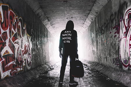 person wearing black and white pullover hoodie while carrying bag thumbnail