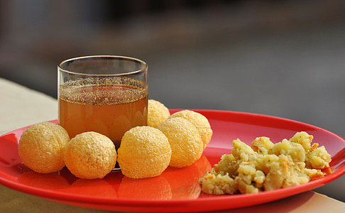 shallow depth of field photo of round fried food on red plate beside rocks glass thumbnail
