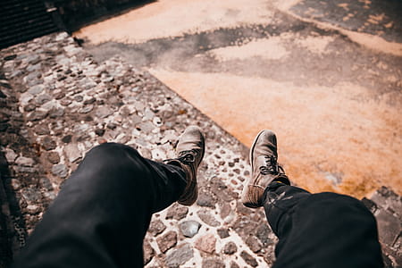 Feet dangling over an old cobblestone road thumbnail