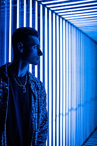 photography of man standing next to lighted wall thumbnail
