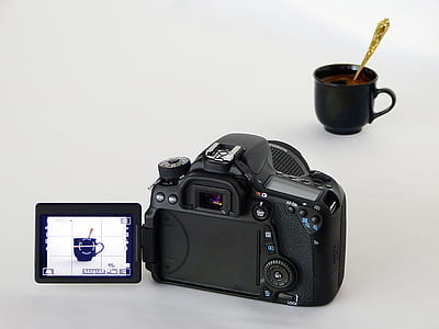 black DSLR camera capturing black ceramic mug with gold-colored spoon thumbnail