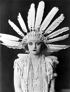 grayscale photography of woman wearing feather headdress thumbnail