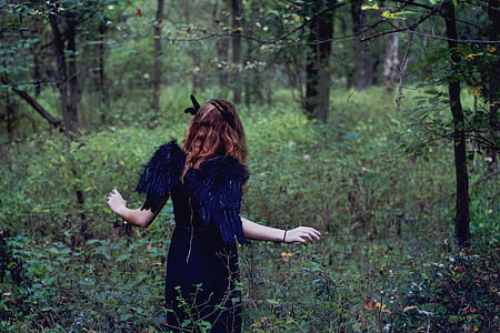 woman wearing blue wings costume standing into woods thumbnail
