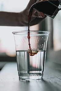 selective focus photography of poured wine on cup of water thumbnail