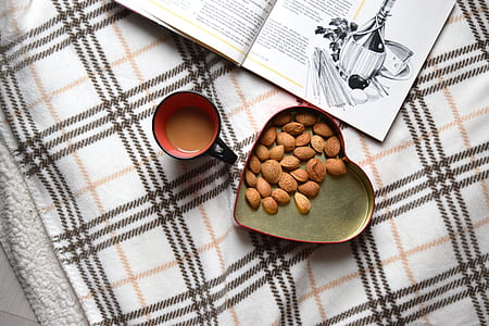 heart-shaped tray with nuts beside mug with coffee thumbnail