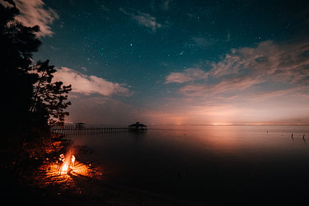 bonfire near body of water thumbnail