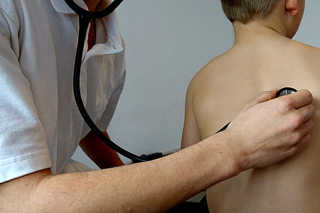 person wearing white polo shirt using stethoscope checking boy back thumbnail
