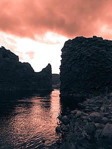 calm body of water with rock formation in front thumbnail