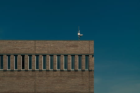white surveillance camera on top of brown building thumbnail