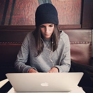 woman wearing black knit cap leaning MacBook thumbnail