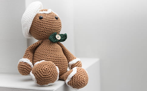 brown bear amigurumi doll on white wooden table thumbnail