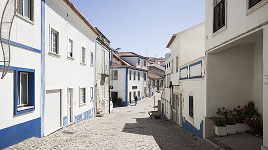 empty alley between white and blue concrete buildings during daytime thumbnail