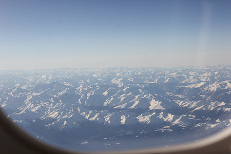 airplane window showing mountains thumbnail