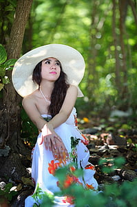 women's white halterneck dress sitting under tree thumbnail