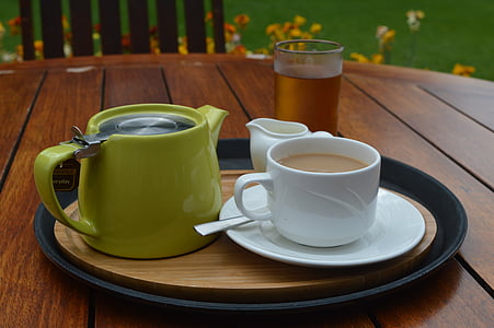 a cup of coffee, creamer, and teapot on top of tray thumbnail