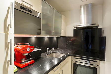 red espresso maker near sink with faucet inside kitchen thumbnail