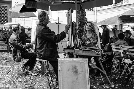 grayscale photography of man painting the face of woman on outdoors thumbnail