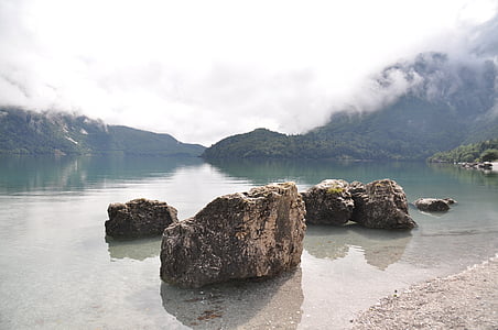 gray rocks on calm body of water at daytime thumbnail