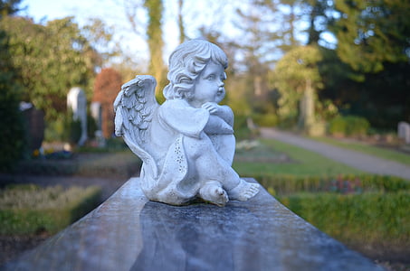 tilt-shift lens photography of sitting white cherub figurine thumbnail