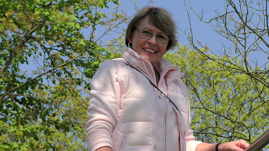woman wearing pink zip-up bubble jacket near green leafed tree thumbnail