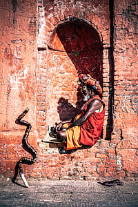 woman sitting on brown concrete brick wall thumbnail